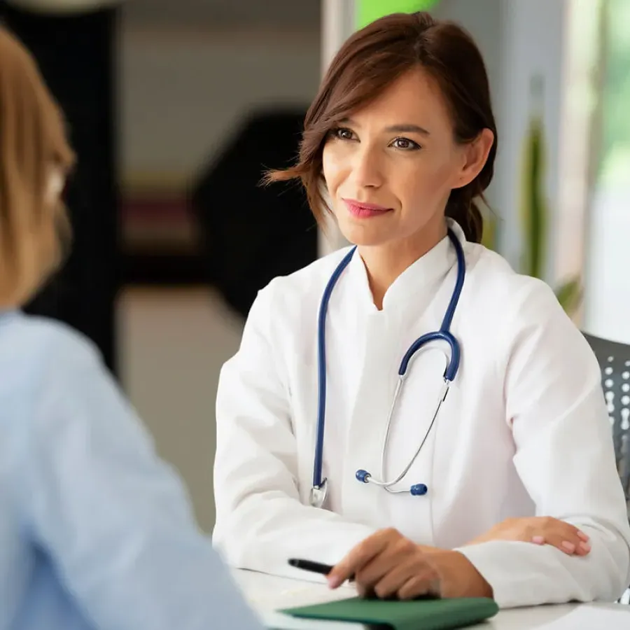 Women's health nurse practitioner smiling with patient during appointment